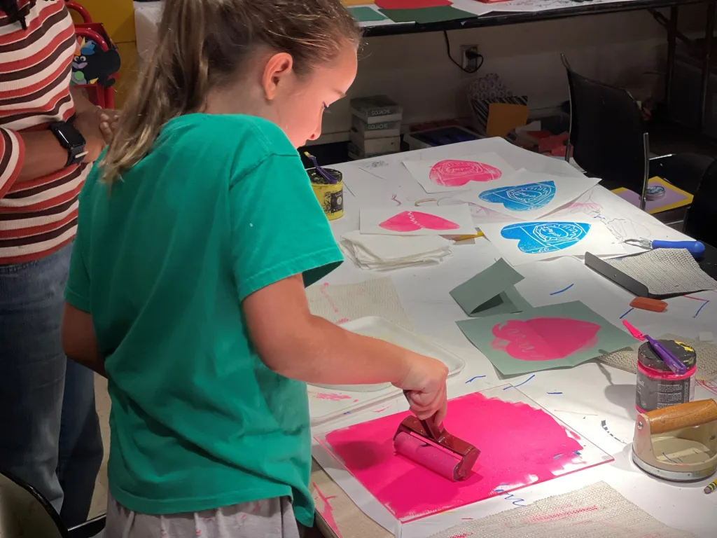 a girl making a print at summer camp