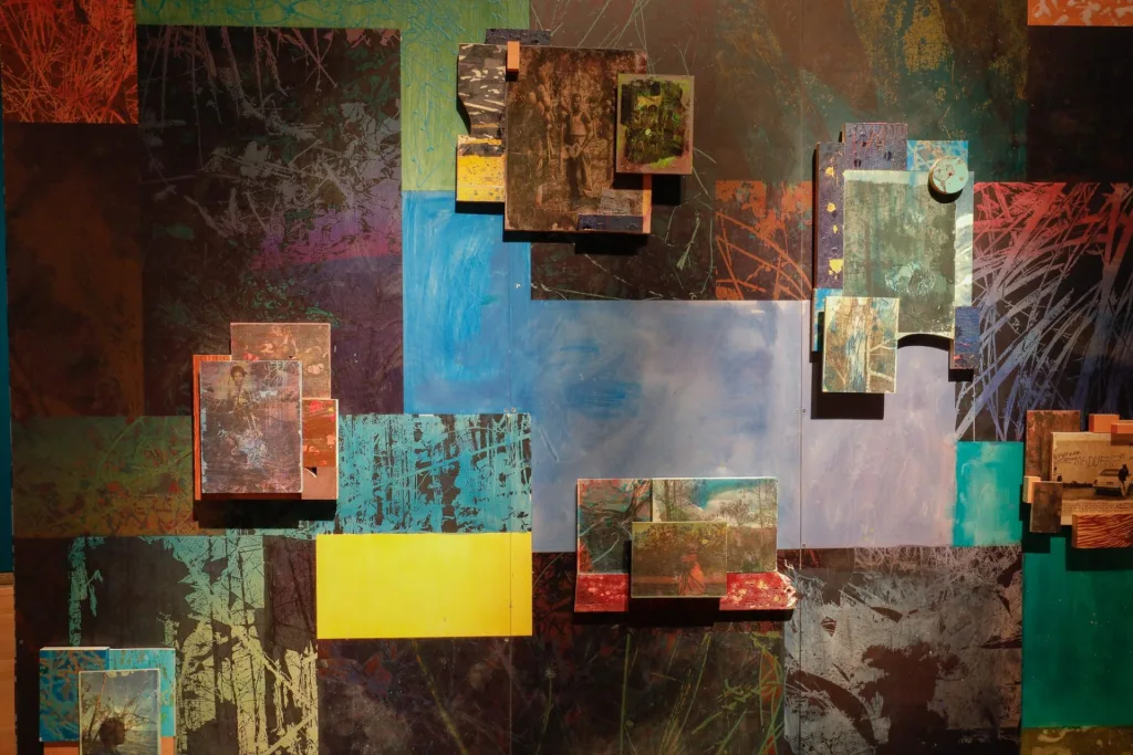 Closeup of colorful paintings and photographs that make up an art installation.