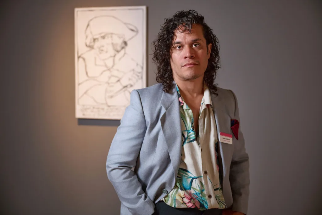 2025 FL Prize artist, Eddie Arroya stands in front of his portrait of Robert-François Damiens