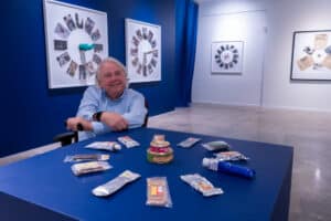 Dennis Scholl sitting at a table with a variety of space memorabilia