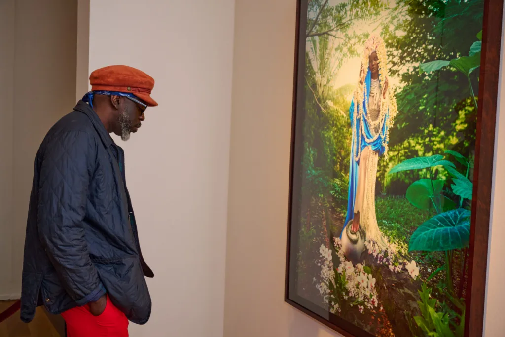 a man looking at an installation of David Lachapelle's work at OMA