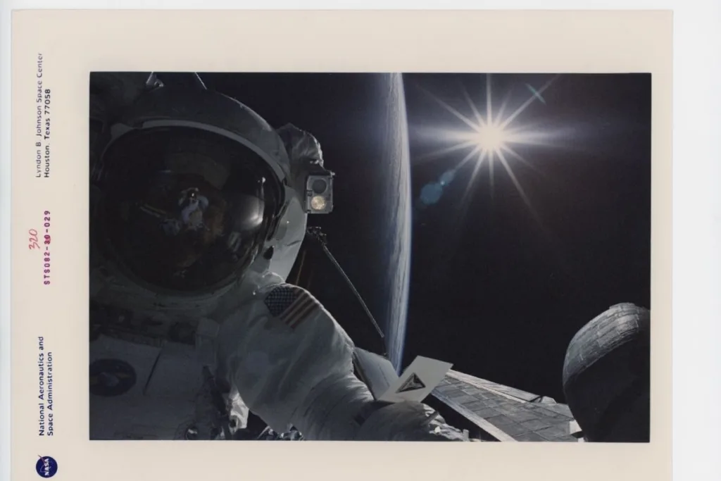 An astronaut silhouetted against Earth and the sun