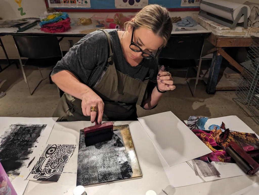 a woman making a print in a art night out class at OMA