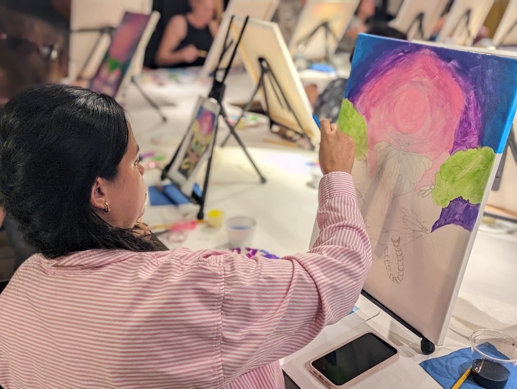A woman painting during an art class at the Orlando Museum of Art