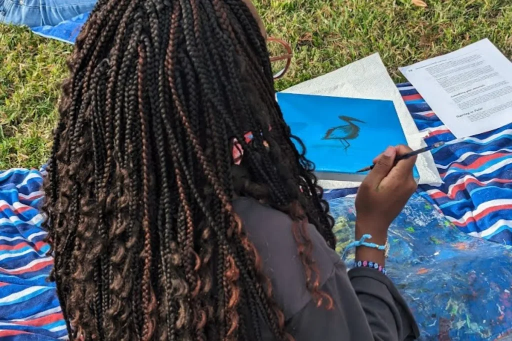 a young girl sketching outside of OMA