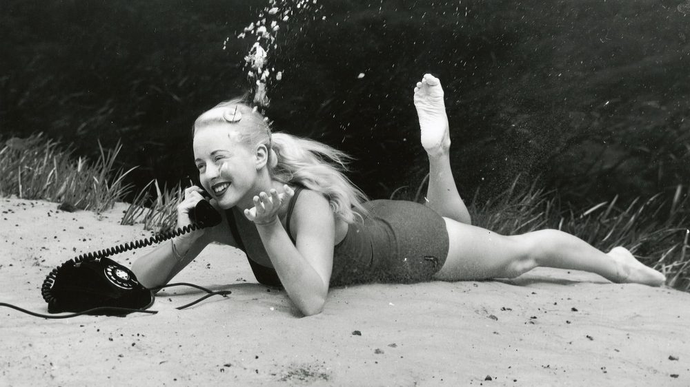 black and white image of woman on a florida beach talking on the phone