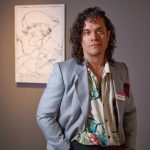 2025 FL Prize artist, Eddie Arroya stands in front of his portrait of Robert-François Damiens